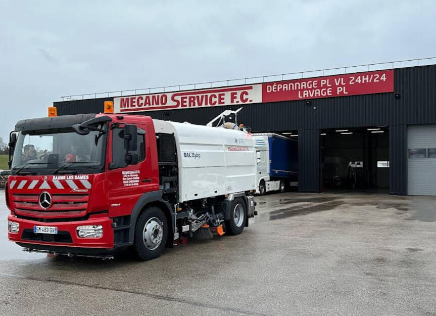 Camion balayeuse devant locaux Mecano Service FC Baume Les Dames avec enseigne dépannage 24h